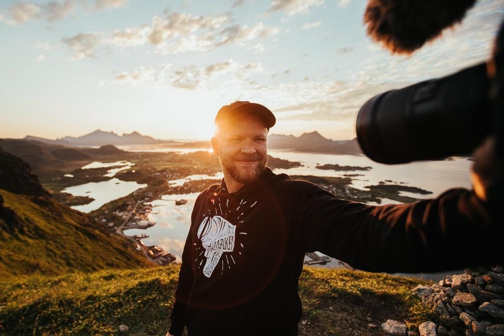 Pria membawa kamera di gunung