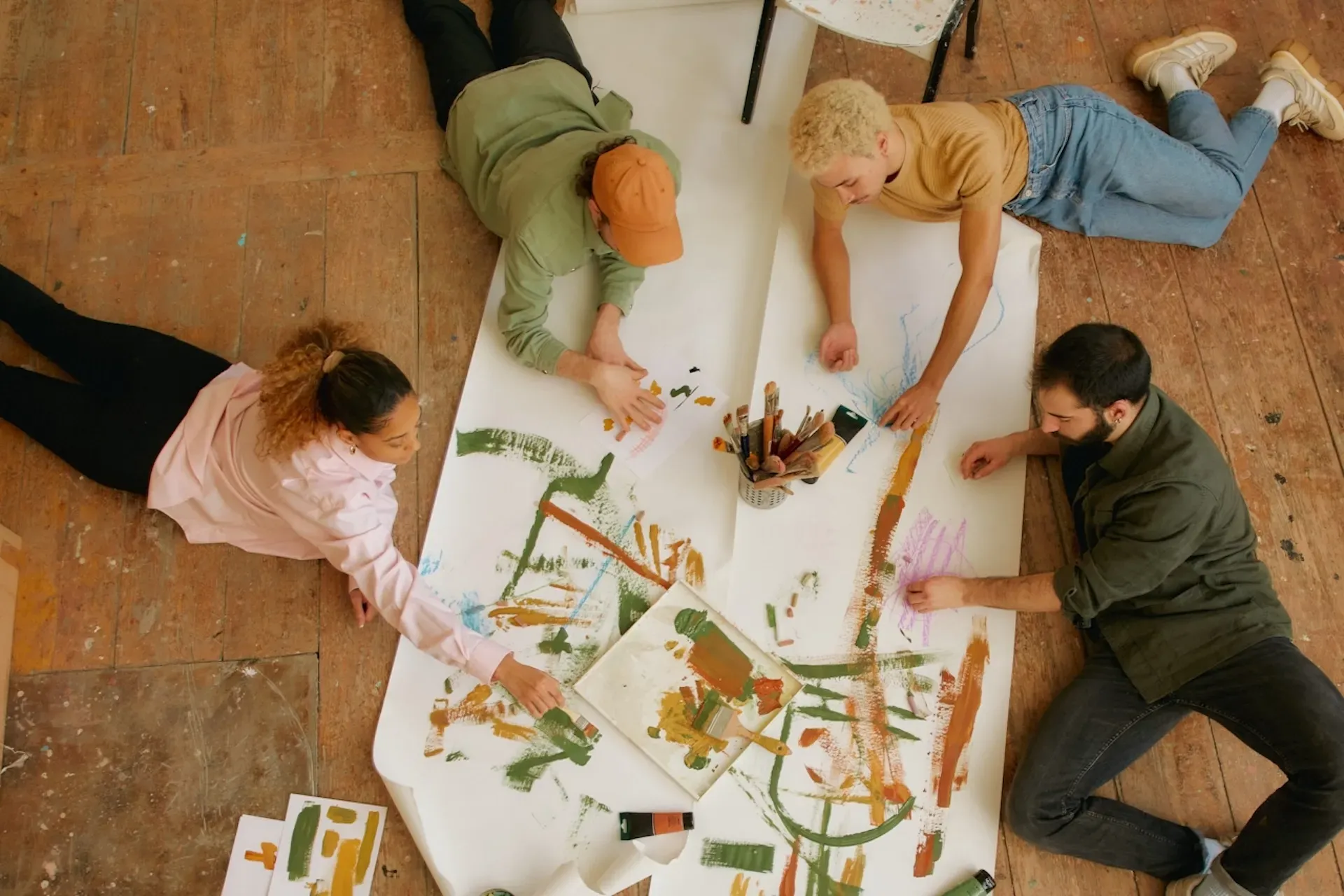 A group of people sitting down and finger-painting