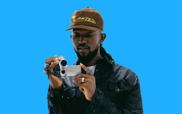 Man in a cap filming with a handheld digital camera